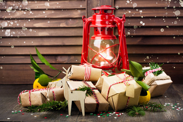 De nombreux cadeaux de Noël décorés et vieille lampe à huile vintage sur fond en bois
 - Photo, image