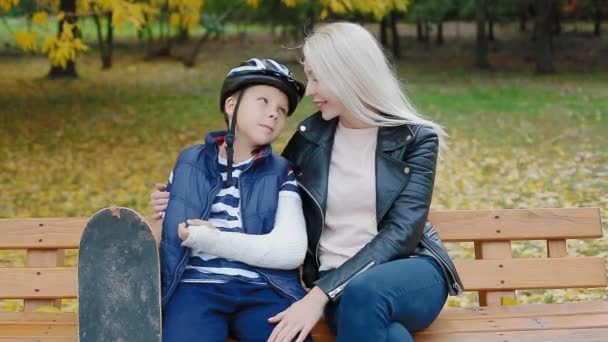Mother and son sitting on the bench in the park - Footage, Video
