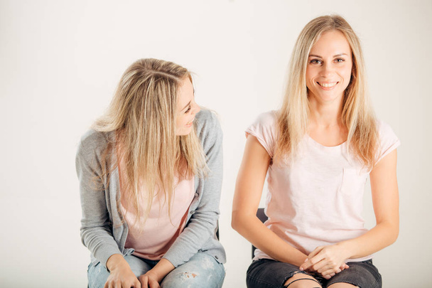 Beautiful two twins sisters together, one woman looking on another - 写真・画像