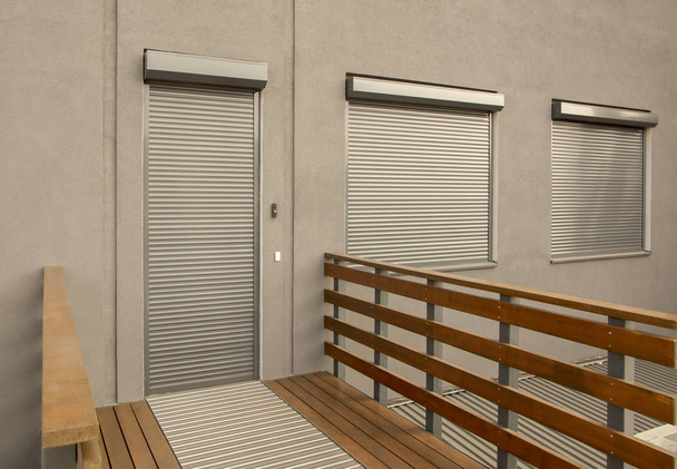 Τυφλοί μετάλλων στις πόρτες και τα παράθυρα της πρόσοψης του σπιτιού - Φωτογραφία, εικόνα