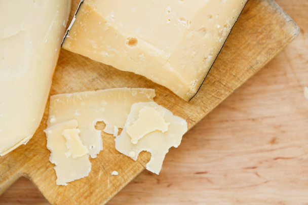 Cheese platter, parmesan on natural wooden board - Foto, imagen
