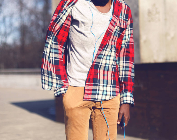 Fashion african man in red plaid shirt listens to music in the c - Foto, immagini