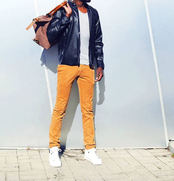 Fashion african man in a black leather jacket with a bag in the  - Fotoğraf, Görsel