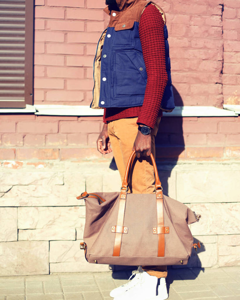 Fashion man wearing a vest jacket, knitted sweater with a bag in - Фото, изображение