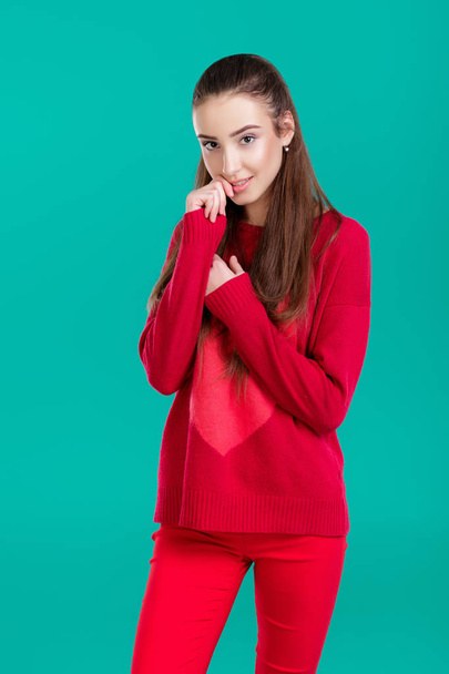woman in red sweater on green background - Foto, afbeelding