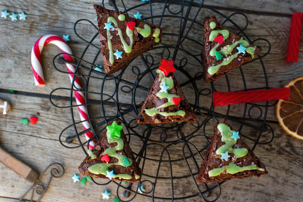 Χριστούγεννα τροφίμων ides, νόστιμο μπράουνις σοκολάτας σε σχήμα χριστουγεννιάτικο έλατο σε ρουστίκ ξύλινα φόντο - Φωτογραφία, εικόνα