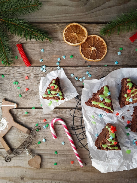 Christmas food ides, delicious chocolate brownies in shape of christmas fir tree on rustic wooden background - Photo, Image