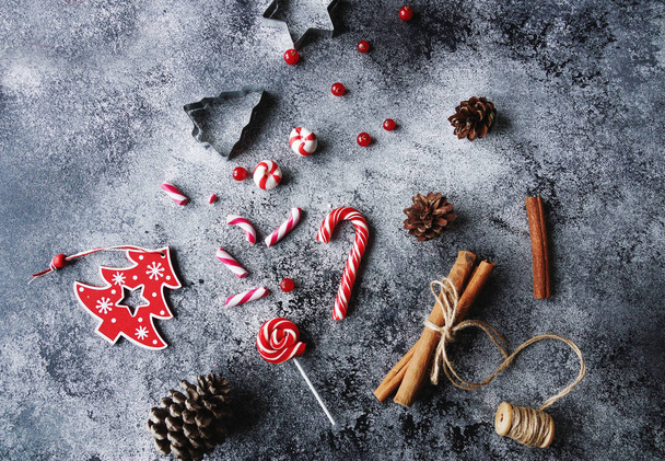 Christmas flat lay home decoration, sweet candies, cinnamon,cones on concrete background - Photo, image