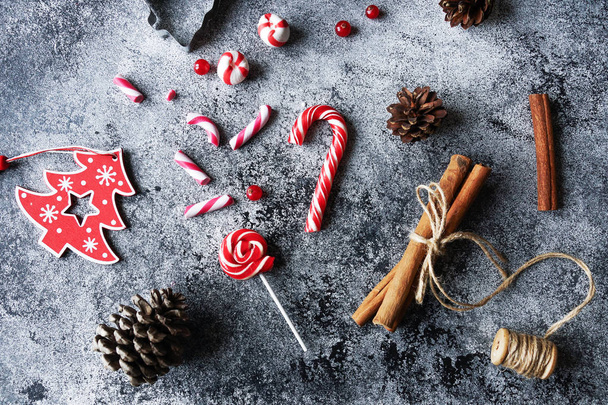 Christmas flat lay home decoration, sweet candies, cinnamon,cones on concrete background - Photo, image