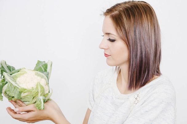 girl keeps cauliflower. Young woman holding cauliflower in her hands. Vegetables in the hands. - Foto, Bild