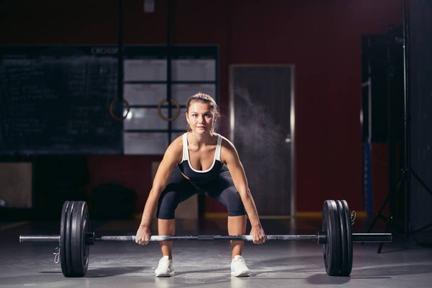 Woman starting barbell exercise standing squat stance. - Foto, Imagen