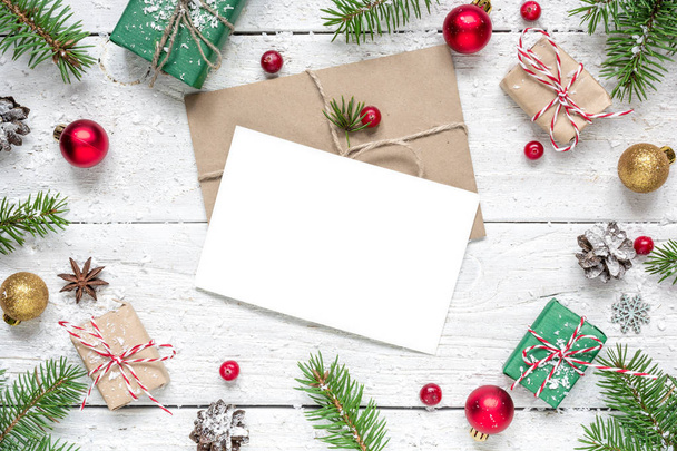 tarjeta de felicitación en blanco de Navidad en marco de ramas de abeto, bayas rojas, decoraciones y cajas de regalo
 - Foto, imagen