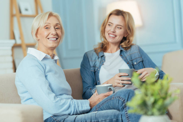 Senior woman looking happy while relaxing with her granddaughter - Foto, Bild