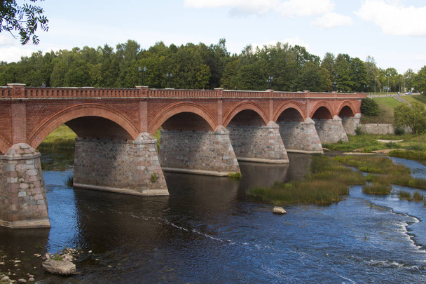 old Brick bridge across the River Venta in the city of Kuldiga Latvia - Photo, Image