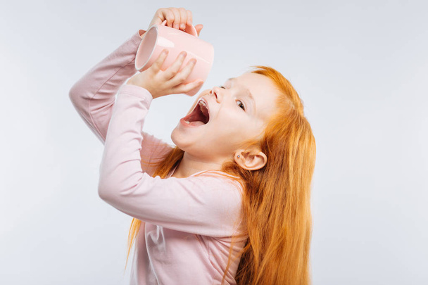 Playful girl raising her cup - Photo, image