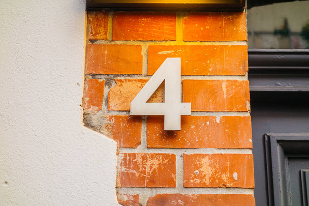 ocel číslo 4 dveře značka na cihlové fasádě - Fotografie, Obrázek