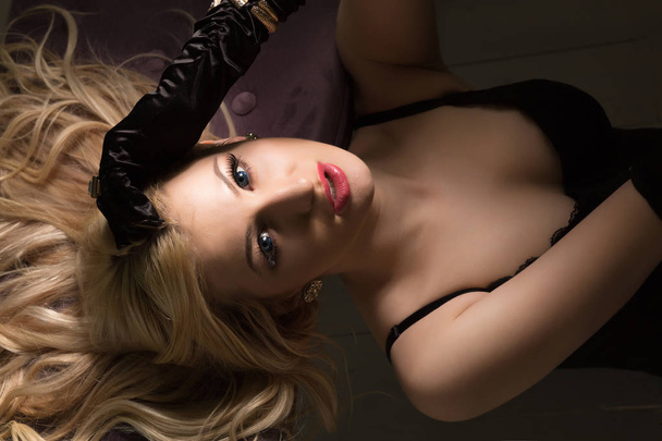 Seductive blonde woman in sexy black lingerie and silk gloves po - Foto, afbeelding