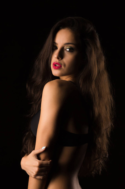 Seductive tanned woman with bright makeup and long hair posing i - 写真・画像