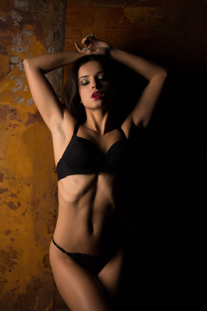 Гламурна засмагла жінка зі спортивним тілом позує в еротичному лінгері
 - Фото, зображення