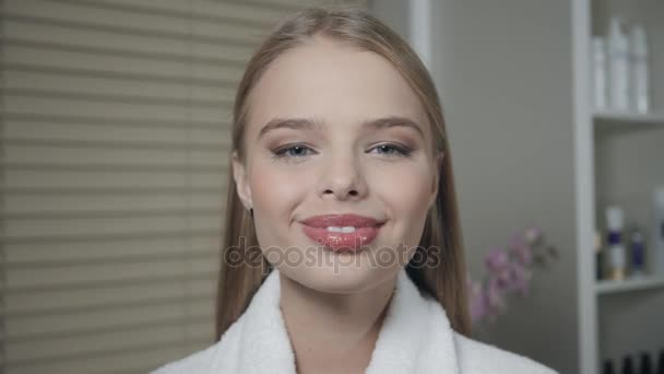retrato de mujer atractiva sonriente rubia. En un albornoz blanco después del procedimiento. Concepto de centro de Cosmetología y SPA
. - Imágenes, Vídeo