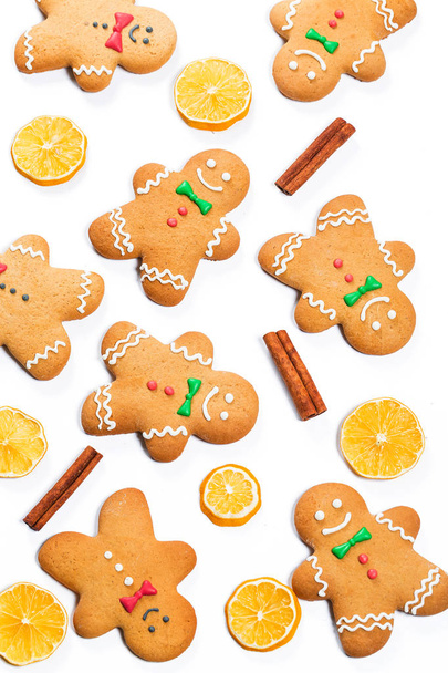 Weihnachten Lebkuchenmänner mit Zitronen- und Zimtstangen auf weißem Hintergrund. ein Symbol für Winter- und Neujahrsferien. - Foto, Bild