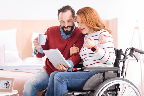 Carefree man and handicapped woman using a tablet - Fotoğraf, Görsel