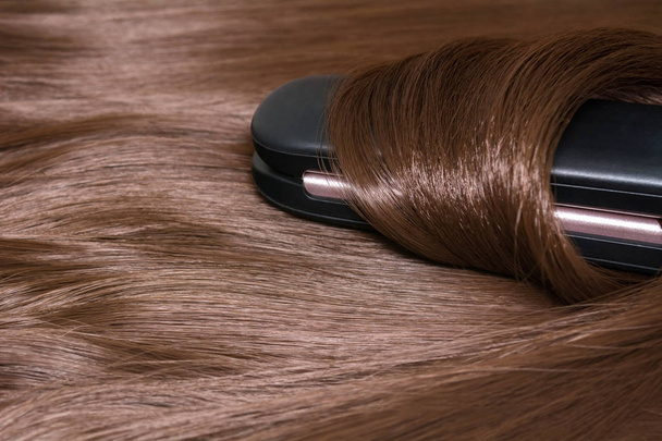 Hair straightener. Brilliant smooth beautiful hair and hair curler - Foto, afbeelding