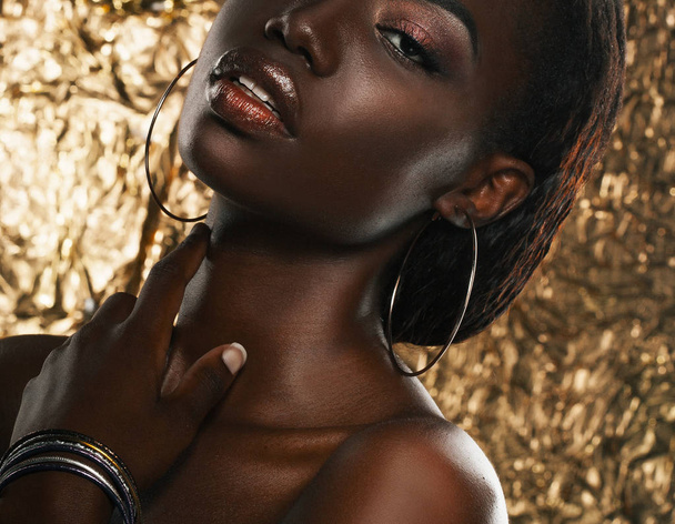 portrait of sensual young african woman against golden background - Foto, imagen