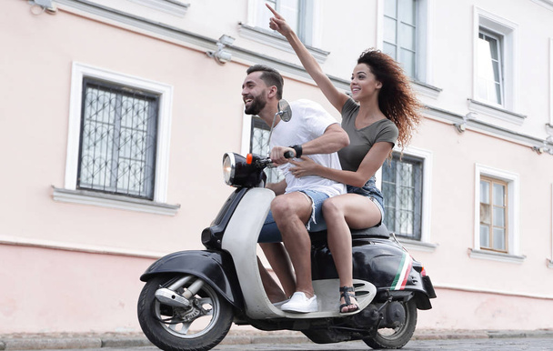 Full length side view of happy couple riding on retro motorbike - Foto, Bild