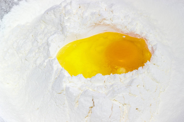 Złamane jaj na kupie mąki zbliżenie - Zdjęcie, obraz