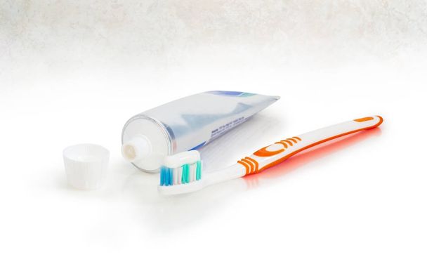 Зубная щетка с зубной пастой и открытая тюбик зубной пасты
 - Фото, изображение