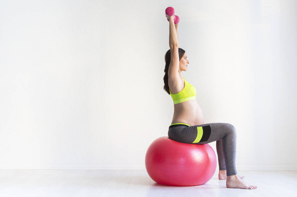 One young pregnant women doing fitness exercises - Fotó, kép