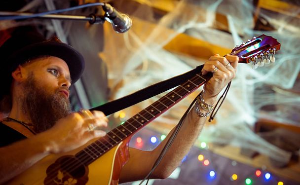 eccentric man in a hat performs at a music bar. Sings songs and plays Irish bouzouki (girar) - Fotoğraf, Görsel