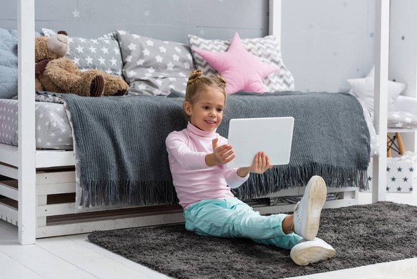 happy little kid sitting on floor and using tablet - Photo, Image