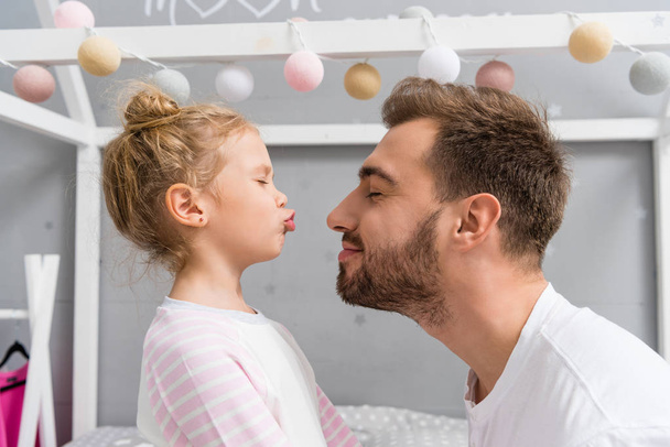 adorável filha beijando pai com olhos fechados
 - Foto, Imagem