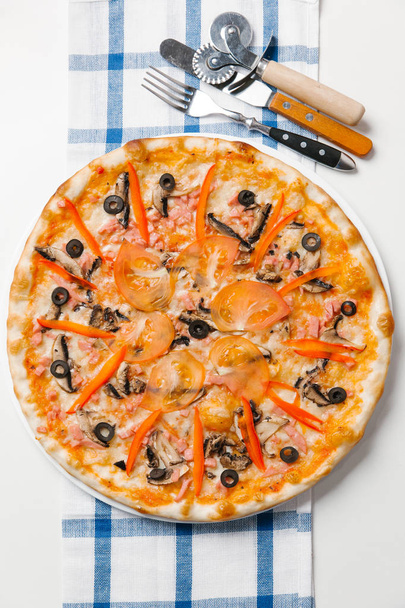 Pizza avec couverts, coupe-pizza, spatule et serviette à carreaux
 - Photo, image
