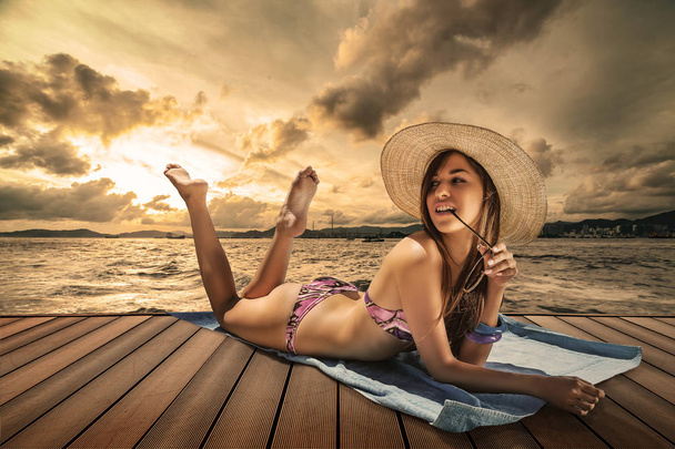brunette model relaxing on a pier sunset - Photo, Image