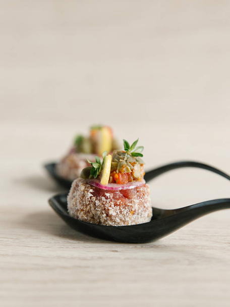Polpette in cucchiai di ceramica con salsa vegetale e fetta di limone su superficie di legno chiaro
  - Foto, immagini