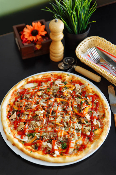 Pizza au poulet, poivre et sauce tomate sur table noire
 - Photo, image