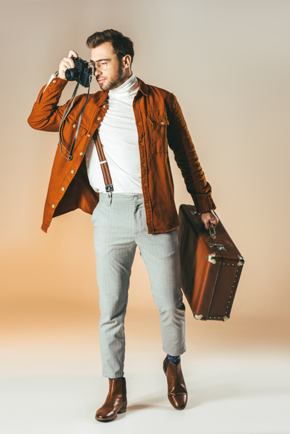 stylish man with suitcase taking picture on photo camera - Valokuva, kuva