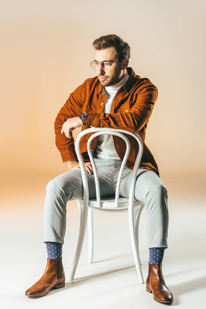 thoughtful man in fashionable clothes resting on chair - Фото, зображення