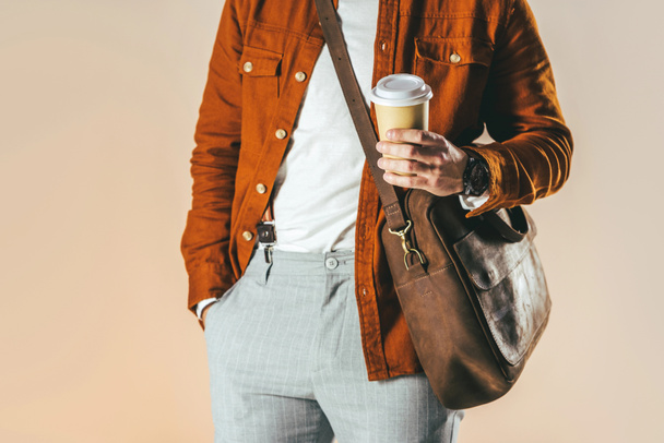 partial view of man in stylish clothing holding coffee to go isolated on beige - Photo, Image
