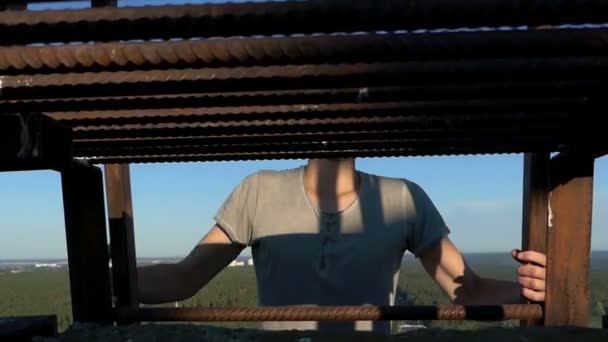 Blonde man klimt de ladder op een hoge huis - Video