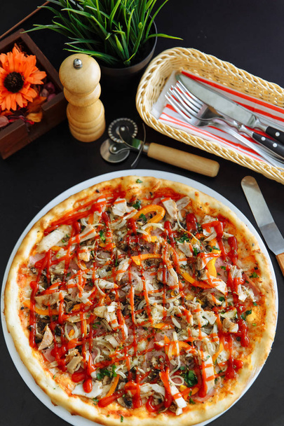 Pizza z kurczakiem, papryka i pomidor sosie na czarny stół - Zdjęcie, obraz
