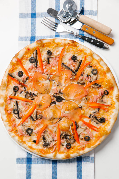 Pizza avec couverts, coupe-pizza, spatule et serviette à carreaux
 - Photo, image