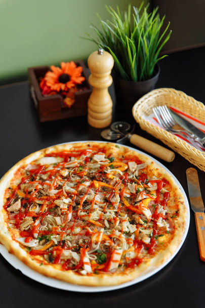 Pizza con pollo, pimienta y salsa de tomate sobre mesa negra
 - Foto, Imagen