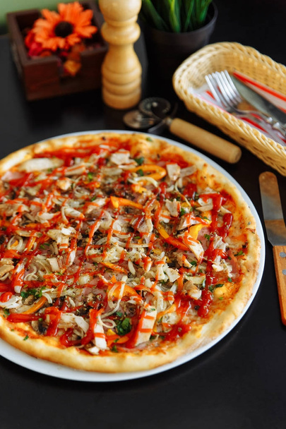 Siyah masada tavuk, biber ve domates soslu pizza - Fotoğraf, Görsel