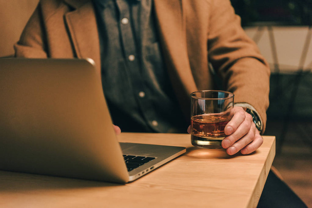 vágott ember lövés pohár whiskey ül asztal, laptop - Fotó, kép