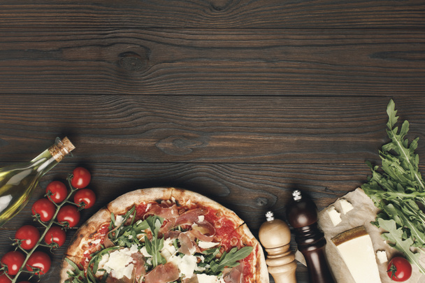 flat lay with italian pizza and various ingredients on wooden tabletop - Photo, Image