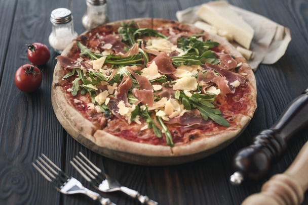 κλείνω πάνω θέα Ιταλική Πίτσα, μαχαιροπίρουνα και συστατικών σε ξύλινες  - Φωτογραφία, εικόνα